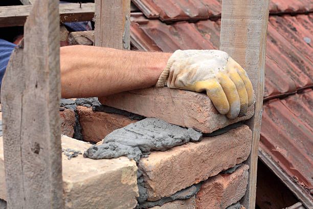 Mason laying brick during a chimney rebuild in Los Alamitos, California