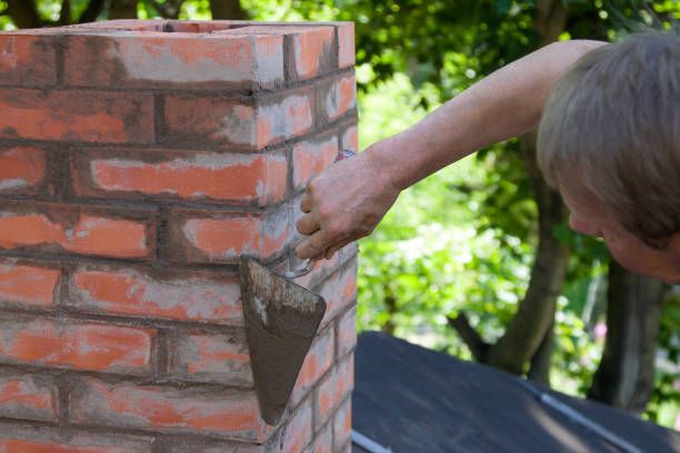 Mason sealing chimney brickwork to stop leaks in Los Alamitos, California