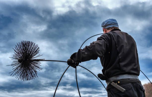 Chimney technician preparing sweep rods for a chimney inspection in Orange County
